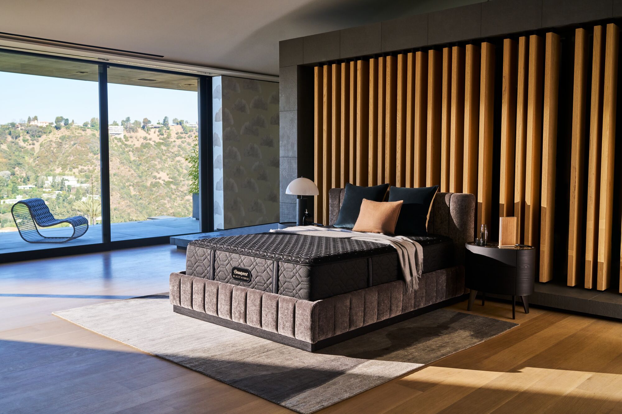 Beautyrest Black Hybrid Series 3 Medium 2 Beautyrest Black Hybrid Series 3 Medium mattress in modern bedroom setting with wooden accent wall, featuring decorative pillows and stylish bedside lamp, showcasing advanced comfort and support features.