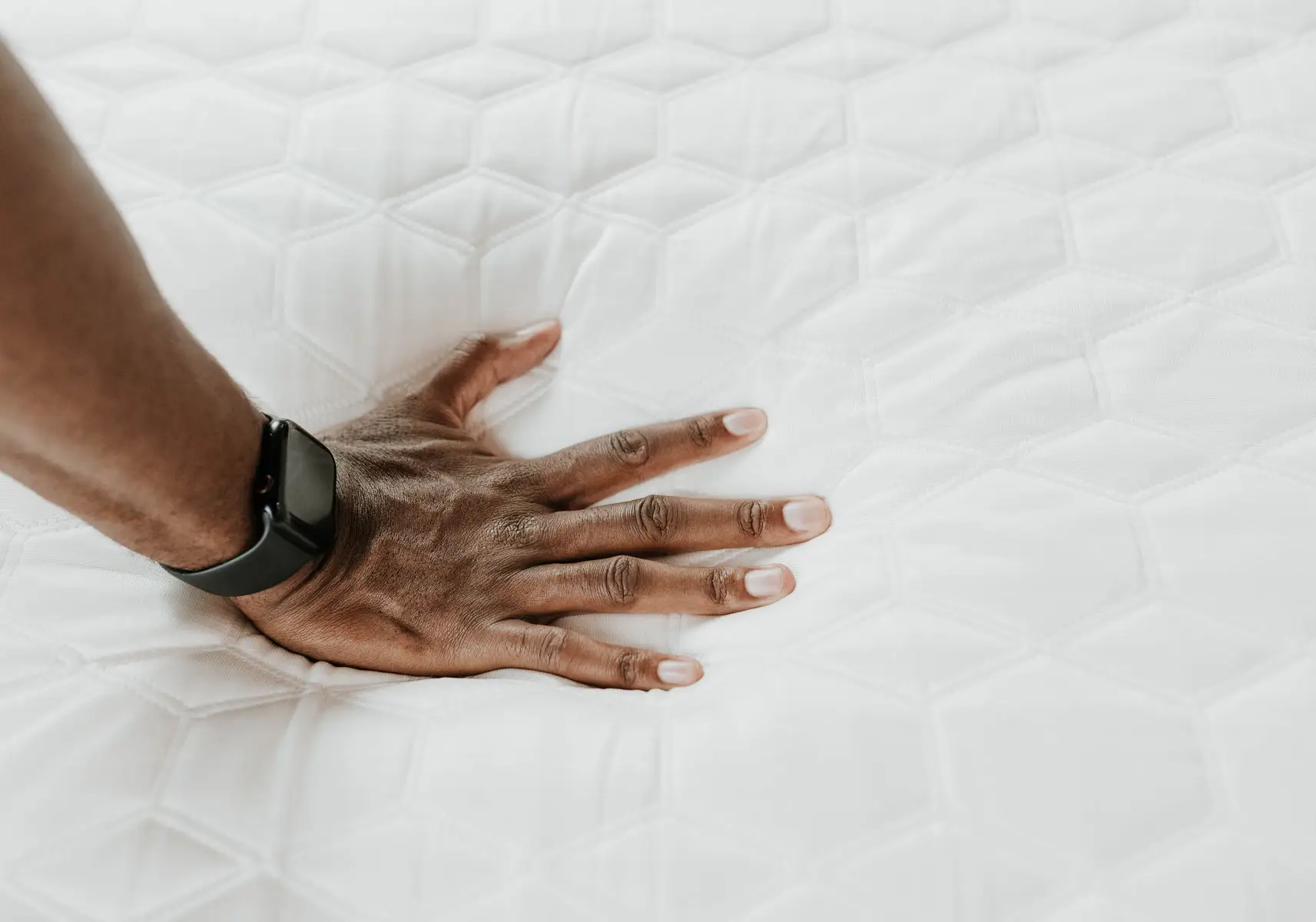 Copper Lux - 12" Soft Memory Foam Mattress With Phase Change Cooling Fabric 3 Hand pressing down on a soft memory foam mattress surface, showcasing its plush texture and comfort features relevant to the Copper Lux 12" mattress with phase change cooling fabric.