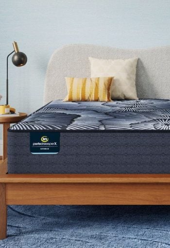 Serta Perfect Sleeper X mattress on a wooden bed frame with decorative pillows, showcasing comfort and style for a better night's sleep at Mattress Superstore.